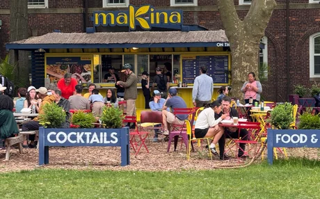 Makina on the Island: the yellow container cafe and its busy beer garden of red and yellow chairs on Governors Island